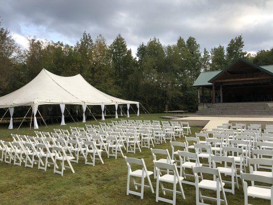 40'x60' Pole Tent with drapes and white resin chairs.