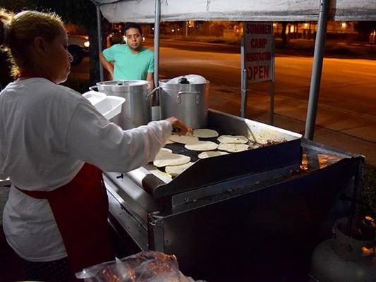 Cook heating up the tortilla for the tacos at El Gorrion.