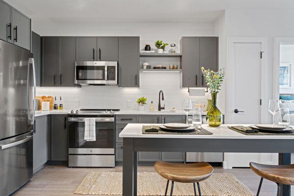 Kitchen with Caesarstone quartz countertops with tiled backsplashes and under-cabinet lighting