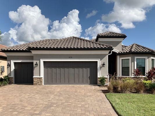 Dark Bronze seamless gutters and White downspouts in Esplanade at Starkey Ranch, Odessa