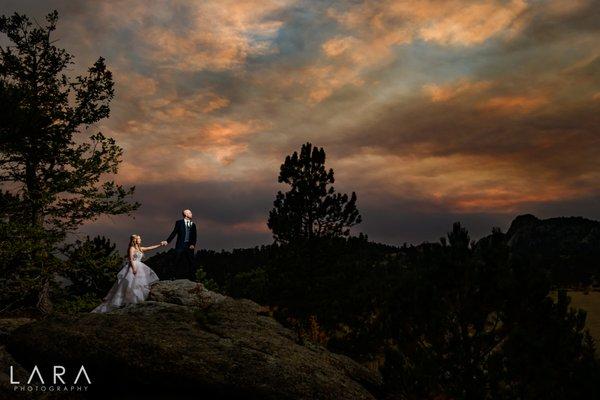 A couple explores a rocky mountain-top during an Estes Park sunset.