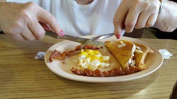 Mom's senior breakfast. One egg, 1 piece of french toast, bacon. Sugar free syrup.