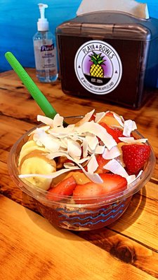 Acai bowl with bananas, strawberries, granola, coconut flakes and peanut butter