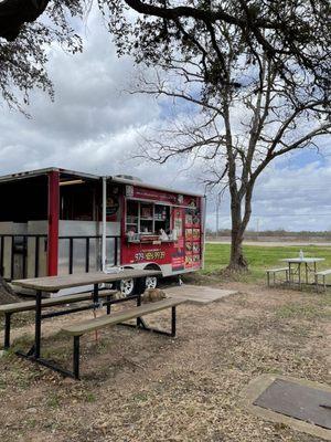 A cute small food truck with two dining tables