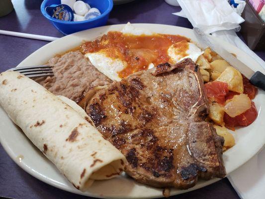 T-bone, over easy eggs with Ranchero sauce, refried beans, potatoes and a tortillas