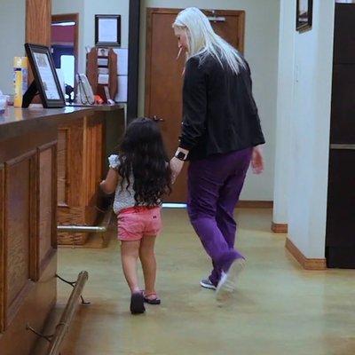 Adult and child walking in to dental office