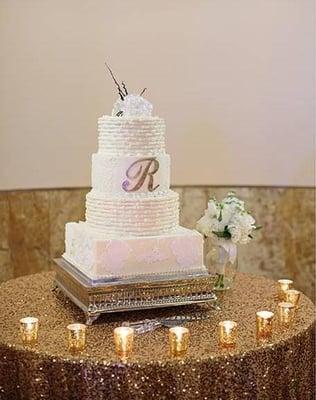 White buttercream with real butter, edible gold leaf gilded Initial.  Hand Made Sugar Rose and buttercream and fondant lace details.