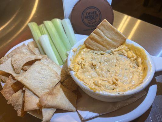 Buffalo chicken dip with blue cheese crumbles, celery and pita.