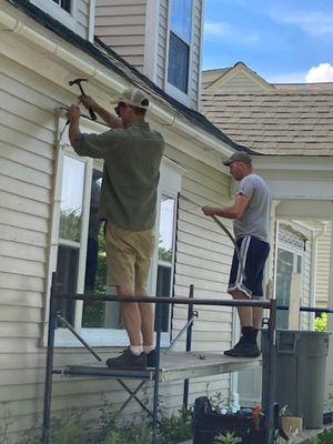 Window installers working on the exterior of a home