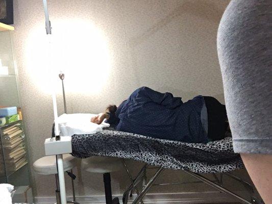 Employee sleeping on waxing table next to me while I was getting my eye brows waxed.