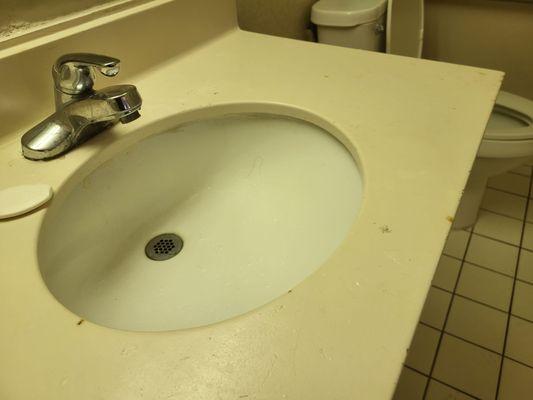 Sink with various cigarette butt burns on it.