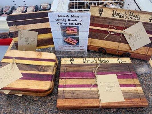 Locally made cutting boards with Manea's Meats wood burned into the board.