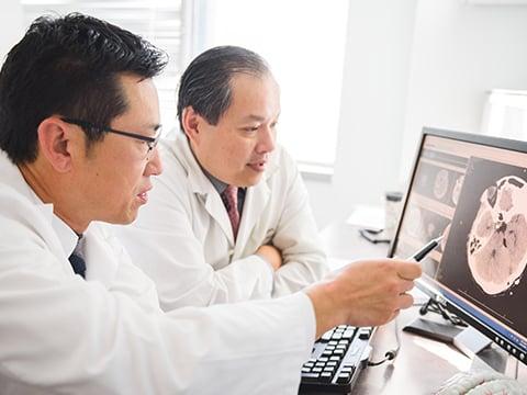 Dr. Lim and Dr. Nguyen examine scans.