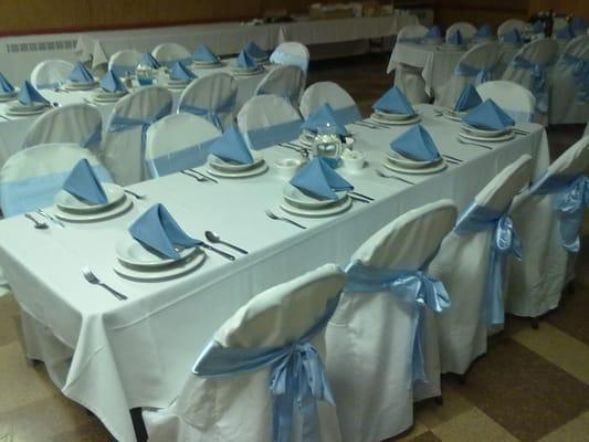 Folding chair cover with light blue sash.