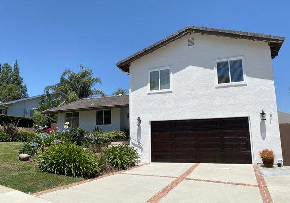 Stained garage door (formerly white) and new white exterior with brown trim paint.