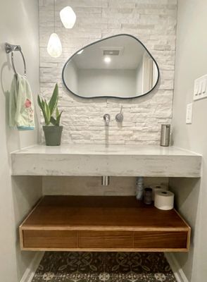 Powder room with zero depth sink and tiled wall