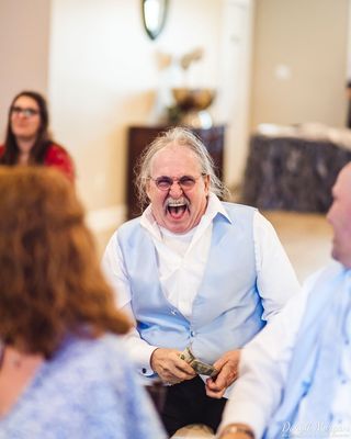 The grooms father at a wedding is having a great time!