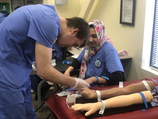 Phlebotomy students drawing blood.