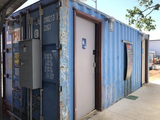 Women's and men's restrooms located in an old CONEX shipping container.