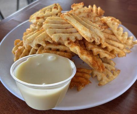 Sea Spuds aka waffles fries seasoned with old bay, cheese sauce on the side