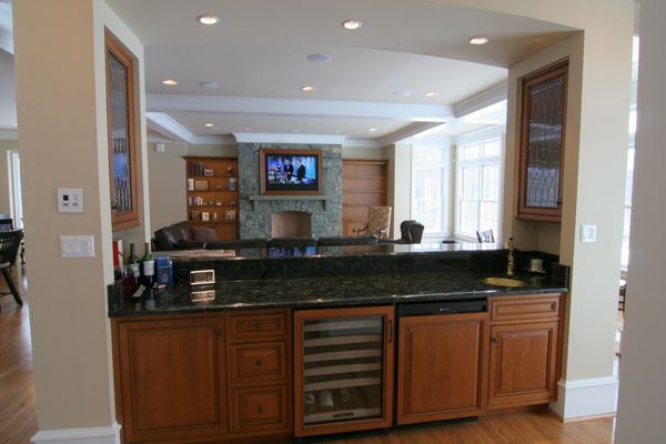 Framed television over fireplace with 3 channel sound bar. In-wall OnQ intercom located to left of bar.