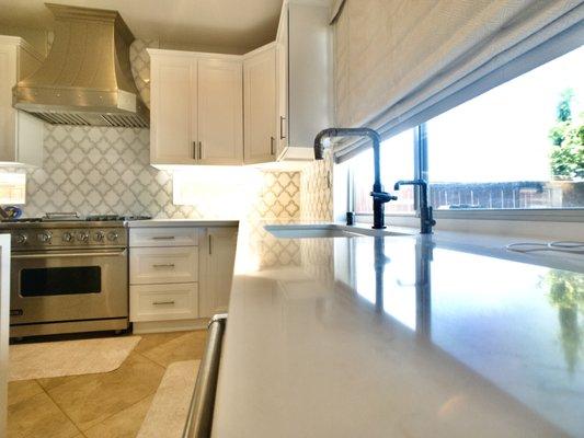 Modern fixtures provide sleek, streamlined silhouettes to compliment both countertops, cabinets and patterned backsplash