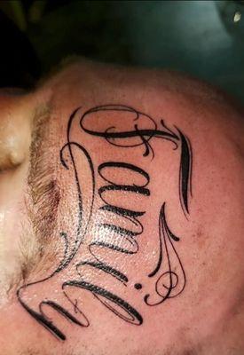 Family script face tattoo by Maria Brady