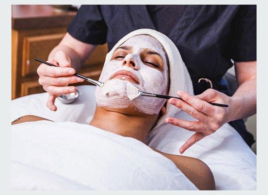 Facial mask being applied with brushes