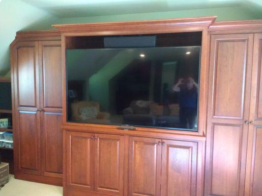 Canapa job - 65-inch TV in cabinet on articulating mount, center channel speaker above. Tight tolerance - 1/4 inch around TV.