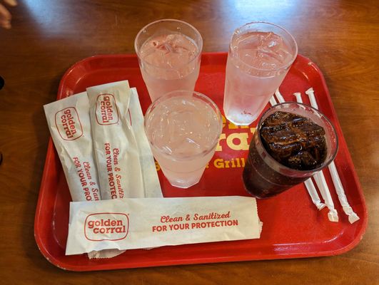 Tray with drinks, eating utensils (cleaned and sanitized for our protection), and straws.