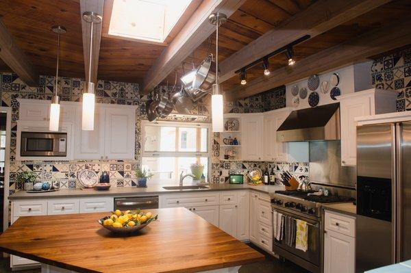 Solid walnut butcher-block island surface in center of refreshed, kitchen remodel. Lg window opens with countertop flowing through to patio.