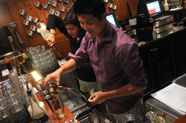 Students get some practice making drinks behind the bar.