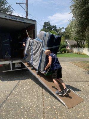 Photo 1: Clark and his assistants removing Steinway from their truck