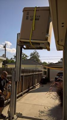 Loading the Condenser unit up on to the roof.