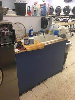 Washing their dishes in the middle of the laundromat