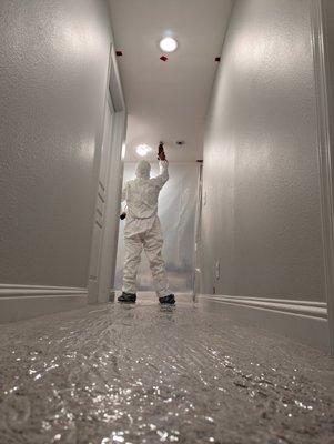 Removing water damaged drywall and wearing proper protective equipment.