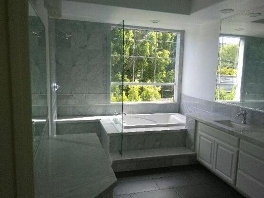 luxurious marble throughout the bathroom with a sunken tub and separate shower