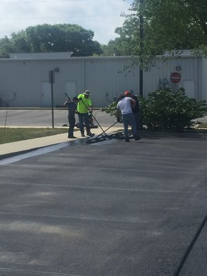 Hand applied sealcoating on commercial parking lot