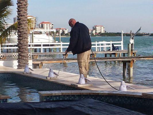 Pressure washing a pool deck to remove bird droppings and grime every 2 months in St. Petersburg.