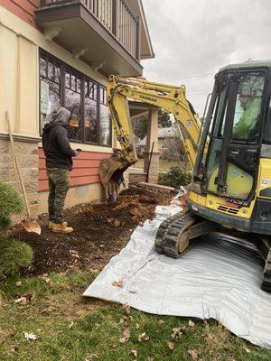 Zeroing in on areas that will host the helical pile assemblies, attaching them to the base of the addition's foundation.