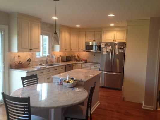 Beautiful kitchen with circle table built into island with a granite counter top