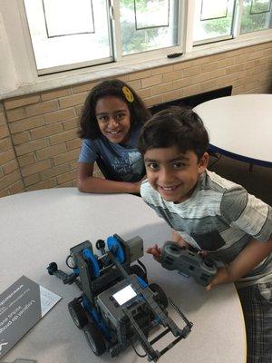 Kids posing with their robotic creation that they controlled via remote control.