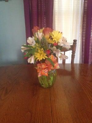 This was a $50 arrangement. Brown tulips, yellow daisies & pink carnations.  70's bow in orange. Arrived late and looks messy.