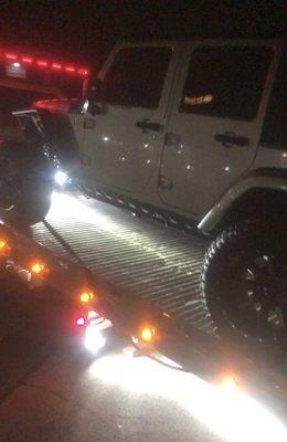 Jeep being pulled onto tow truck