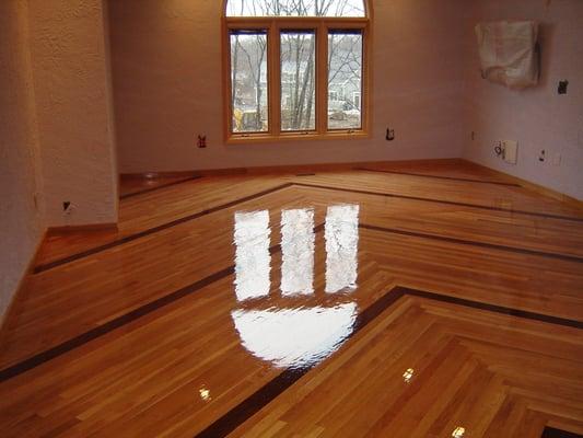 White oak flooring laid in a V pattern,  the ebony stripes are actually stain