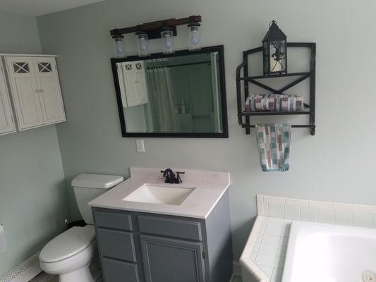 Bathroom with new vanity top, sink, faucet, lighting, GFCI outlet with nightlight, towel racks, cabinets, walls and vanity base re-painted.