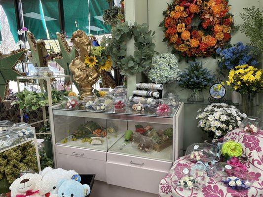 Station of pre-designed corsages (i think with faux flowers) with band options for corsages displayed on bracelet display rack