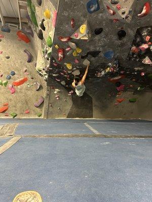 Person climbing in the overhang section of progression climbing gym