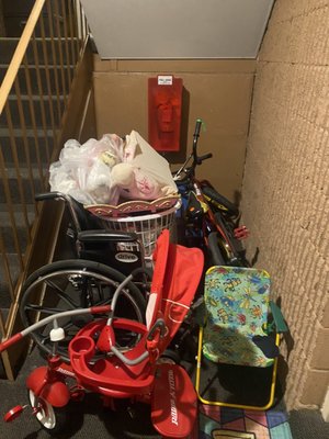 Junk blocking the fire extinguisher in the apartment hallway. You can even get to the fire extinguisher should a fire occur.