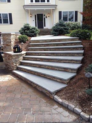 Steps with stone risers and bluestone slabs. Driveway made by pavers.